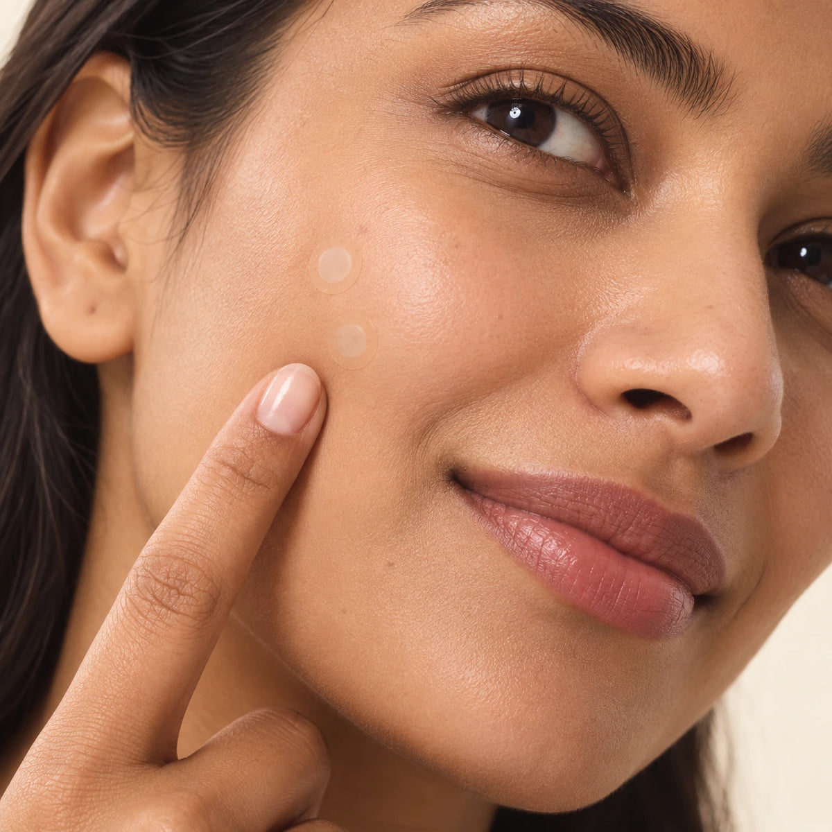Close-up of two small NoTrace patches worn on a cheek